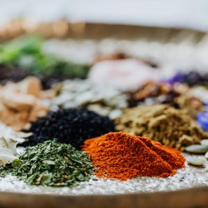 Close-up of colorful spices and herbs on a tray, showcasing a vibrant palette.