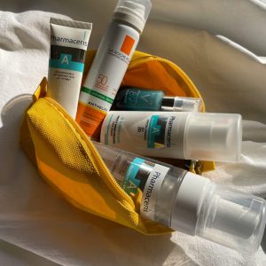 Assorted skincare products in a yellow pouch, captured in natural lighting.
